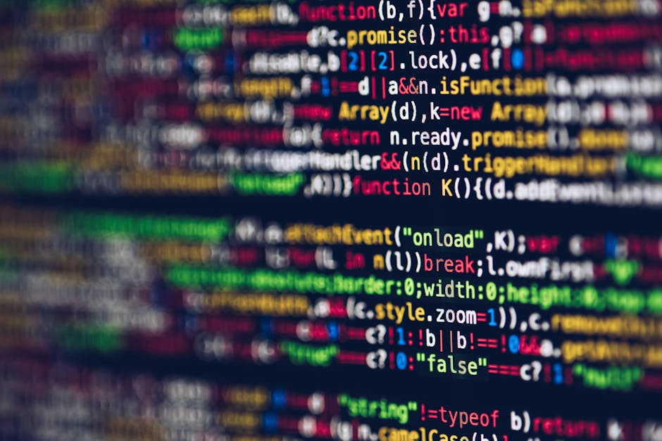 Image of a computer screen displaying colorful lines of code in HTML, JavaScript, and CSS, with syntax highlighting in red, blue, green, yellow, and white. The code is slightly blurred, with focus on